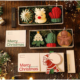Set of Christmas-themed candles and cards on a wooden surface